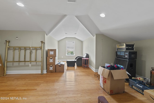 additional living space with light hardwood / wood-style flooring and lofted ceiling