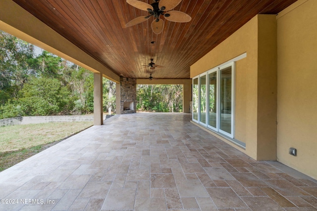 view of patio featuring ceiling fan and an outdoor stone fireplace