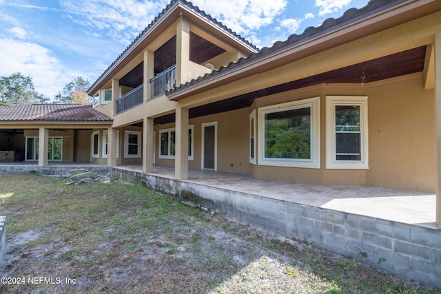 back of property with a balcony and a patio area