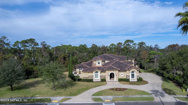 mediterranean / spanish home featuring a front lawn