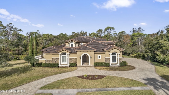 mediterranean / spanish-style house featuring a front lawn