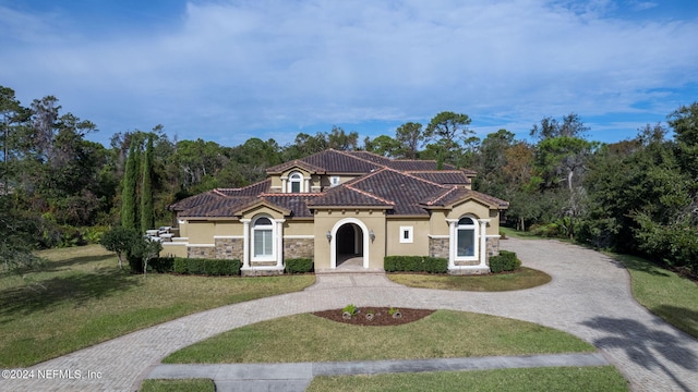 mediterranean / spanish home with a front lawn