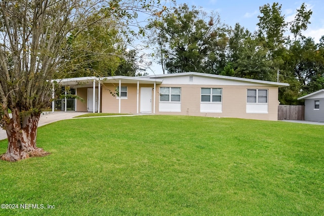 view of front of home with a front yard and a carport