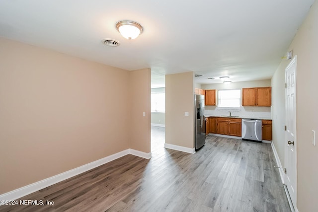 kitchen featuring stainless steel appliances, light hardwood / wood-style floors, and sink