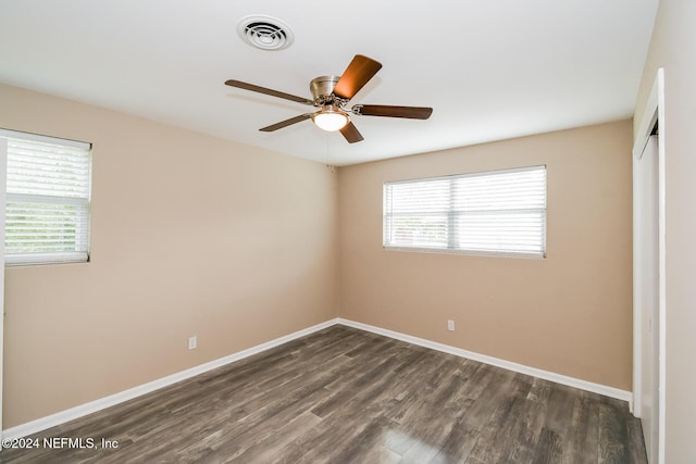 spare room with ceiling fan and dark wood-type flooring