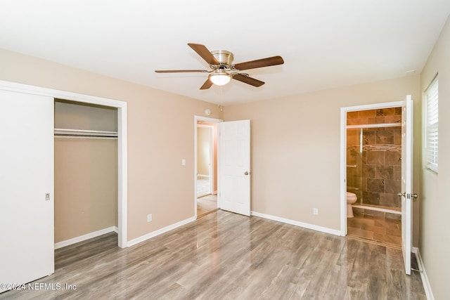 unfurnished bedroom featuring a closet, ceiling fan, hardwood / wood-style floors, and ensuite bathroom