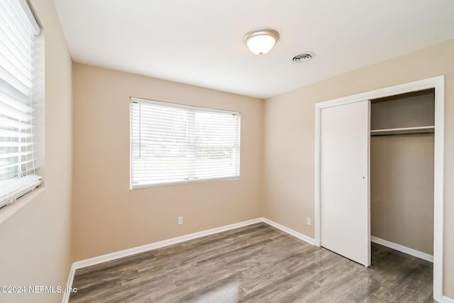 unfurnished bedroom with wood-type flooring and a closet