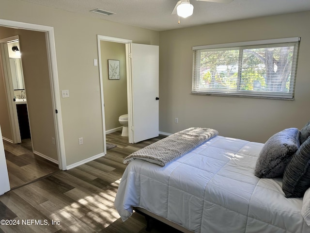 bedroom featuring ceiling fan, dark hardwood / wood-style flooring, sink, and connected bathroom