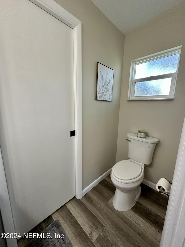 bathroom with toilet and hardwood / wood-style flooring