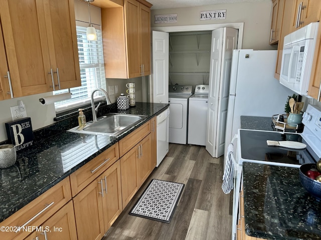 kitchen with white appliances, washer and clothes dryer, decorative light fixtures, dark wood-type flooring, and sink