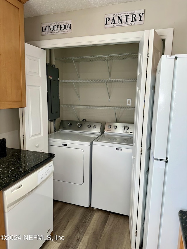 clothes washing area featuring washer and dryer, dark wood-type flooring, a textured ceiling, and electric panel