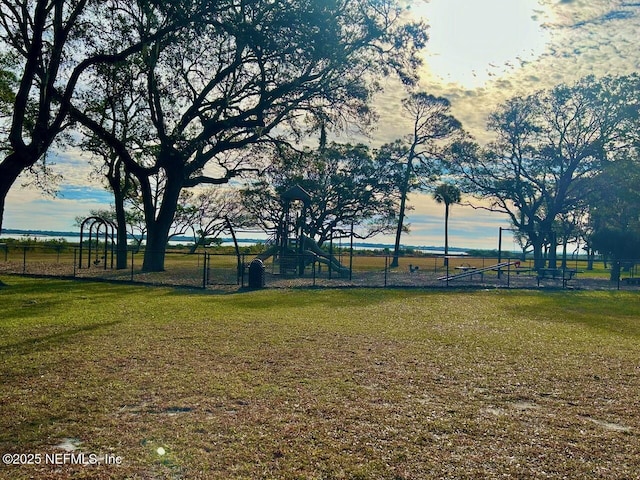 yard at dusk featuring a playground