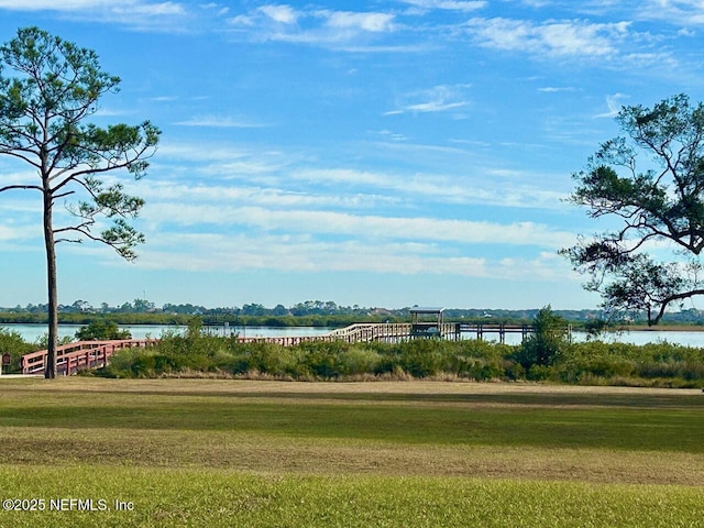 view of property's community with a water view and a yard