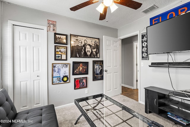 carpeted living room featuring a textured ceiling