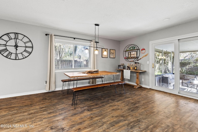 dining room with a textured ceiling, a wealth of natural light, and dark wood-type flooring