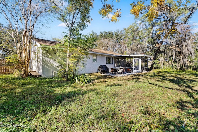 back of property featuring a sunroom and a yard