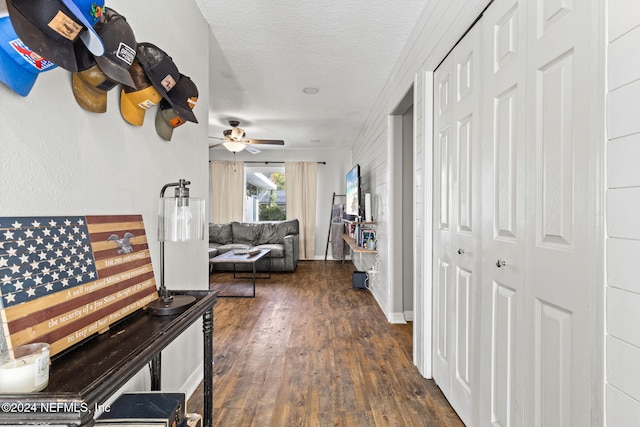 hall with a textured ceiling and dark hardwood / wood-style floors