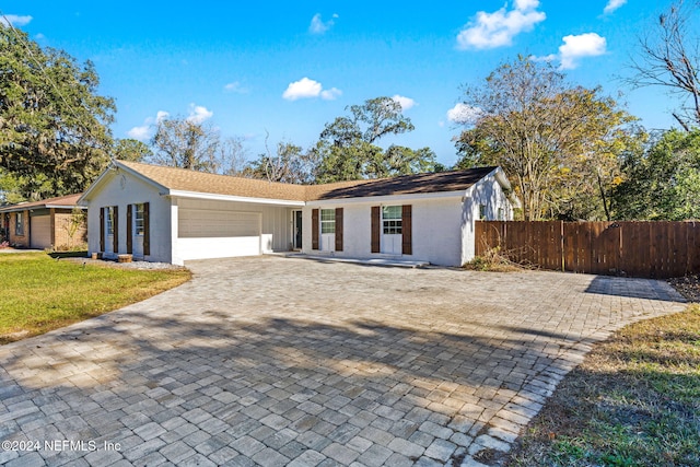 single story home featuring a garage and a front yard