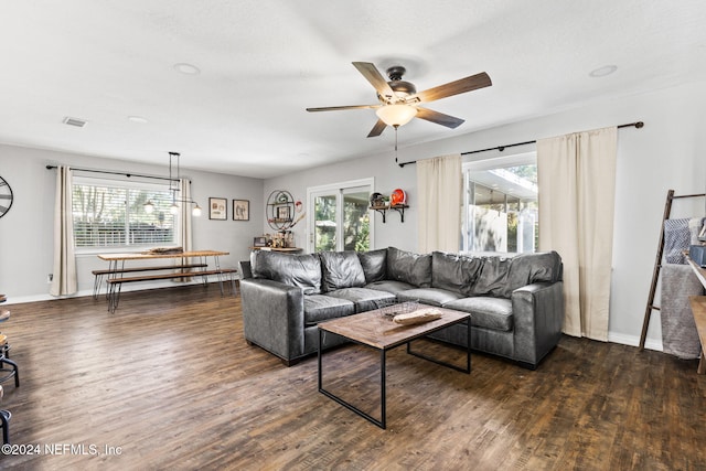 living room featuring a textured ceiling, ceiling fan, and dark wood-type flooring