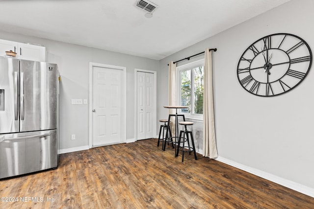 kitchen featuring stainless steel fridge, white cabinets, and dark hardwood / wood-style floors