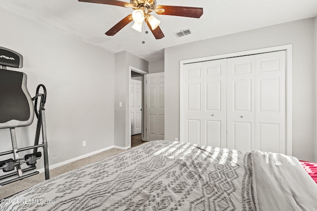 bedroom with carpet flooring, a textured ceiling, a closet, and ceiling fan