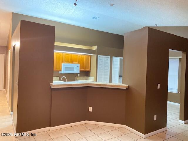 kitchen featuring kitchen peninsula and a textured ceiling