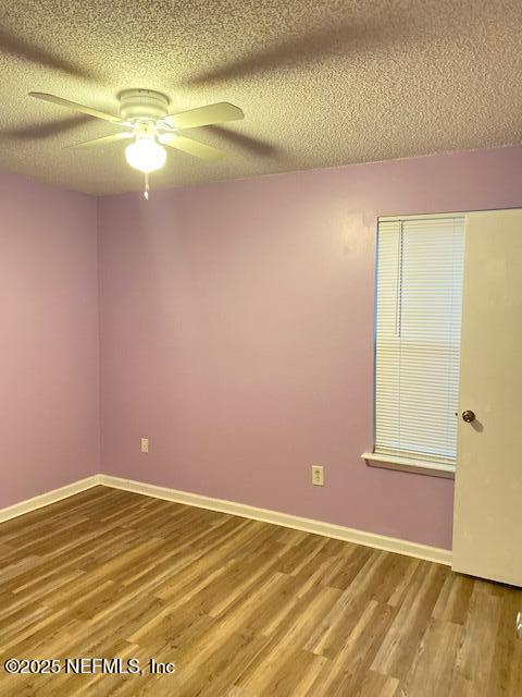 spare room featuring hardwood / wood-style flooring, ceiling fan, and a textured ceiling