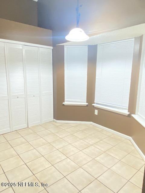 interior space with light tile patterned floors and a closet