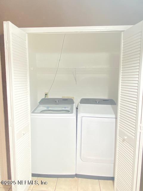 washroom featuring separate washer and dryer and light tile patterned flooring