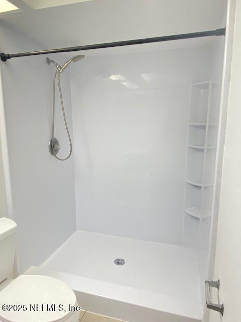 bathroom with toilet and a shower