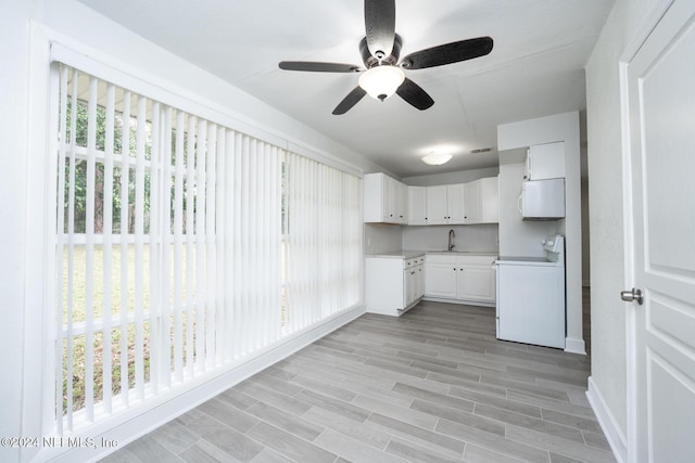 kitchen with range, sink, light hardwood / wood-style flooring, ceiling fan, and white cabinetry