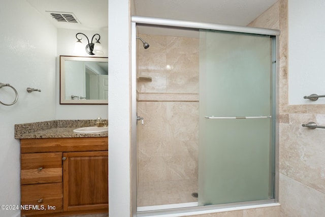 bathroom featuring walk in shower, vanity, and tile walls