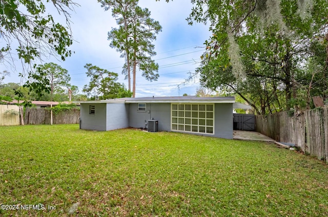 back of property with a lawn and cooling unit