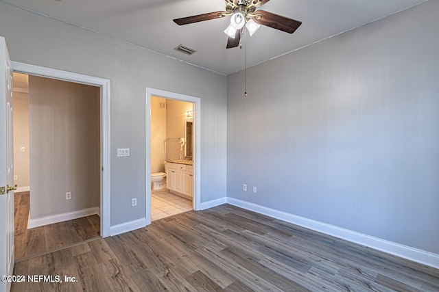 unfurnished bedroom featuring light hardwood / wood-style floors, ceiling fan, and ensuite bathroom