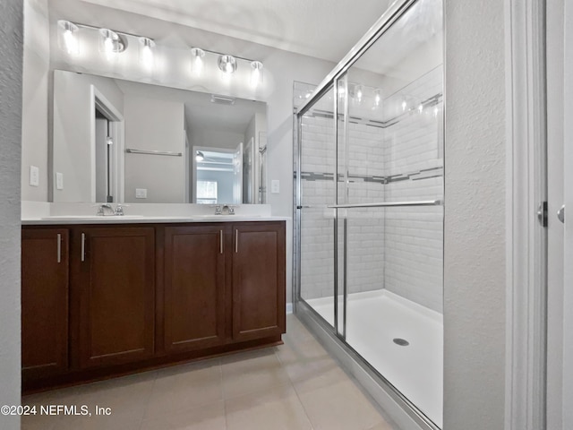 bathroom featuring tile patterned flooring, vanity, and an enclosed shower