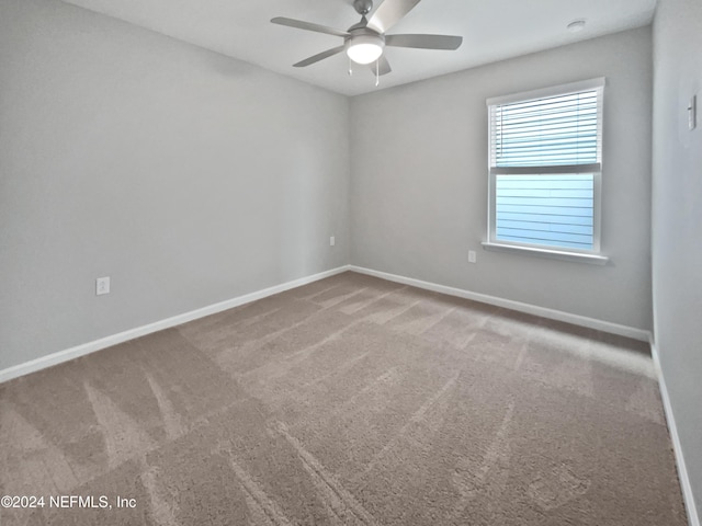 carpeted spare room with ceiling fan