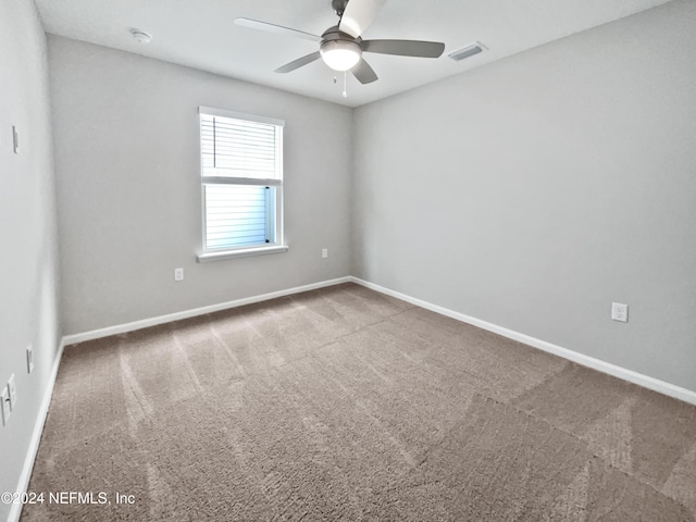 carpeted spare room with ceiling fan