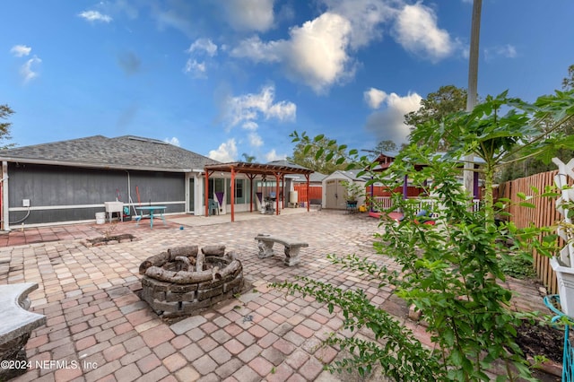 view of patio / terrace featuring a pergola, a fire pit, and a storage unit