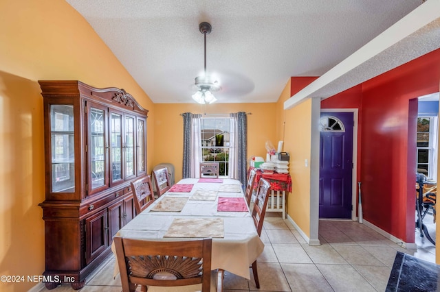 tiled dining space featuring a textured ceiling, ceiling fan, and vaulted ceiling