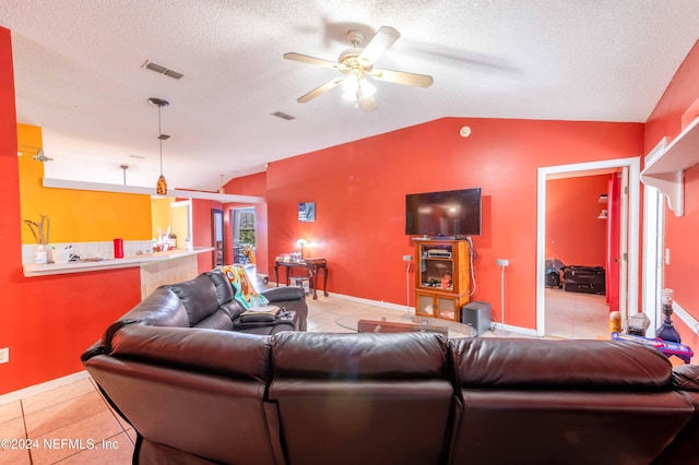 living room with ceiling fan, lofted ceiling, a textured ceiling, and light tile patterned floors