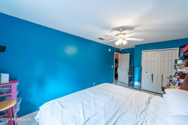 unfurnished bedroom with ceiling fan, a closet, light tile patterned floors, and a textured ceiling