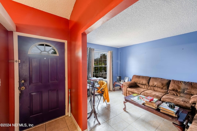 foyer with vaulted ceiling, light tile patterned floors, and a textured ceiling