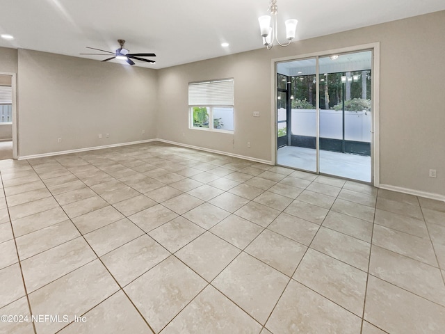 tiled empty room with ceiling fan with notable chandelier