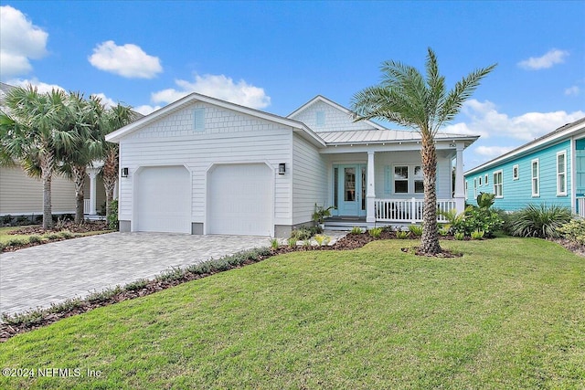 view of front of home featuring covered porch, a garage, and a front yard