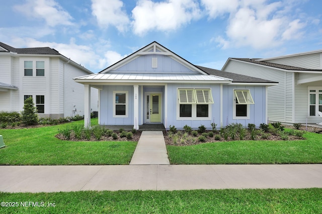 166 Blue Hampton Dr, Ponte Vedra, FL 32081 - view of front facade featuring board and batten siding, a porch, a front lawn, and metal roof