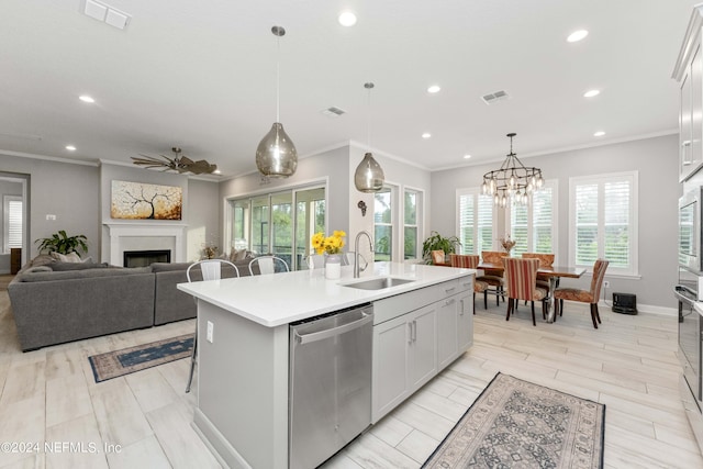 kitchen with dishwasher, a center island with sink, ceiling fan with notable chandelier, sink, and decorative light fixtures