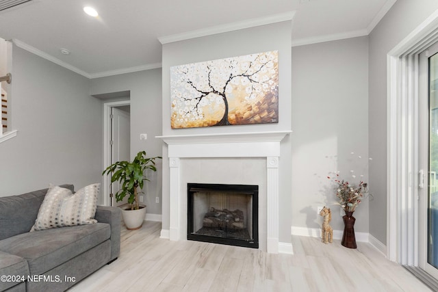 living room with a tile fireplace, light hardwood / wood-style flooring, and ornamental molding