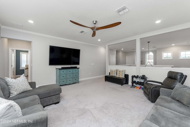 carpeted living room featuring ceiling fan and crown molding