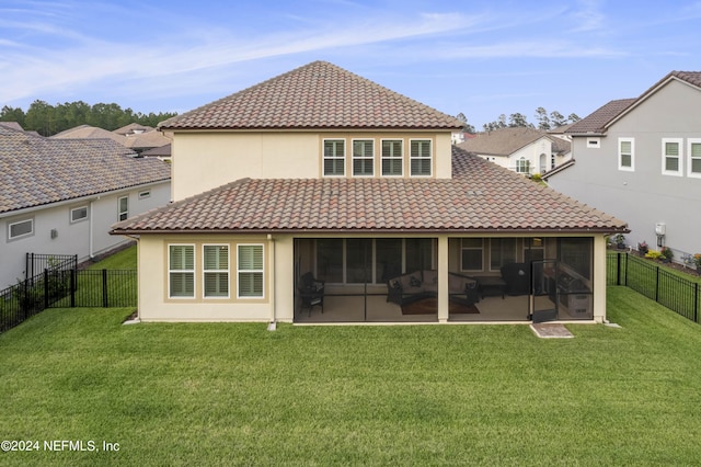 back of house featuring a sunroom and a lawn