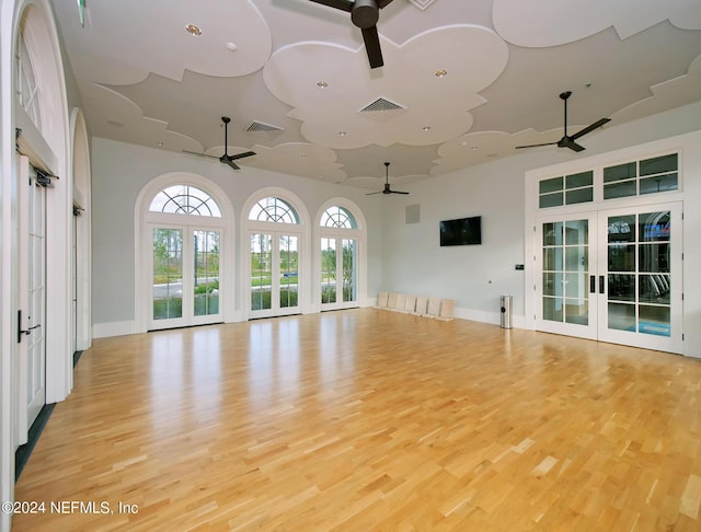 unfurnished living room with french doors and light hardwood / wood-style floors